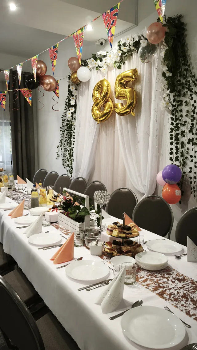 Nakrycia stołu i złote balony na 85. urodziny